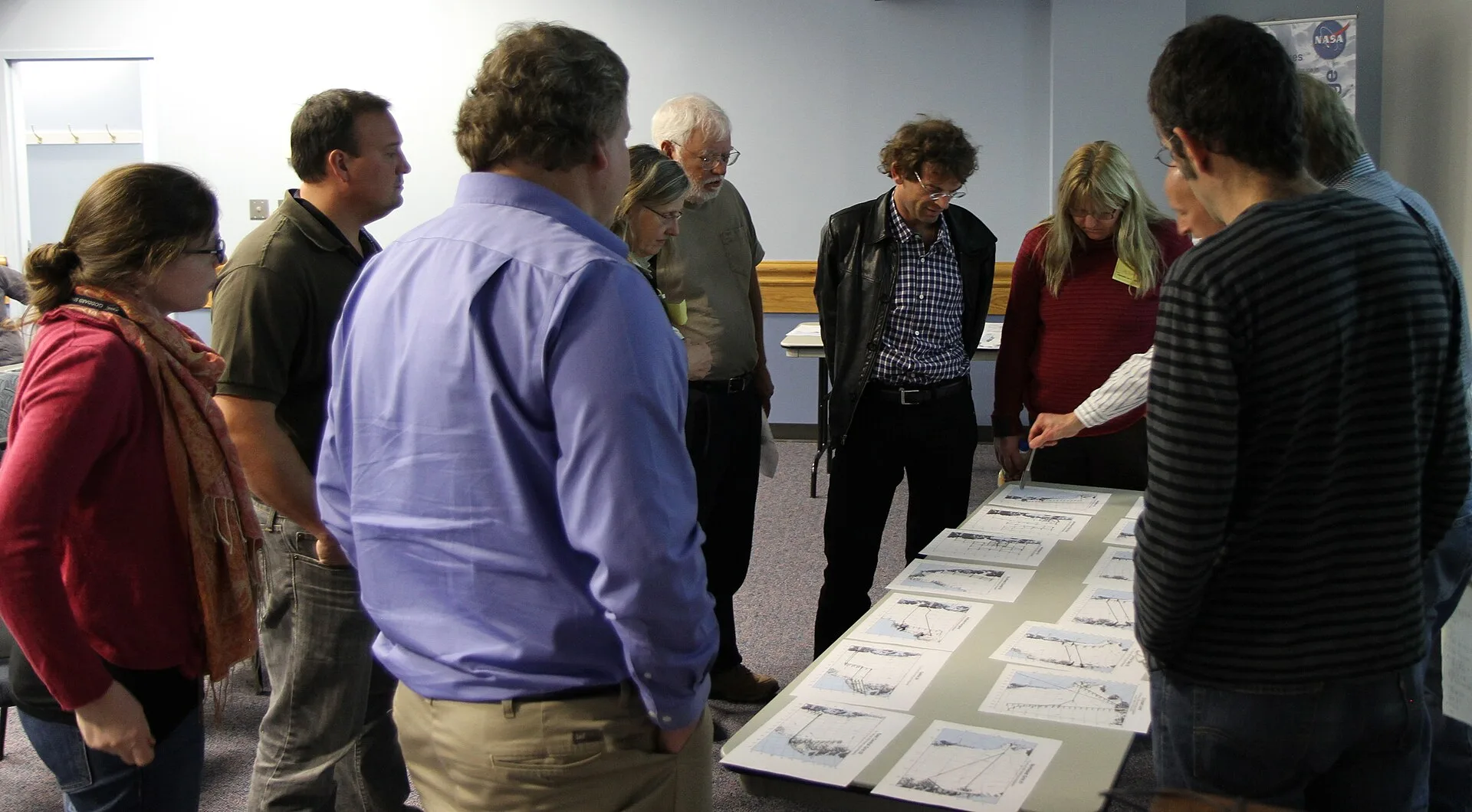 Science team members at the January 2013 IceBridge science team meeting review printed copies of proposed flight lines. Printing flight plans and sorting them onto tables corresponding with high, medium and low priorities allowed for a more intuitive and efficient flight plan review process. IceBrid
